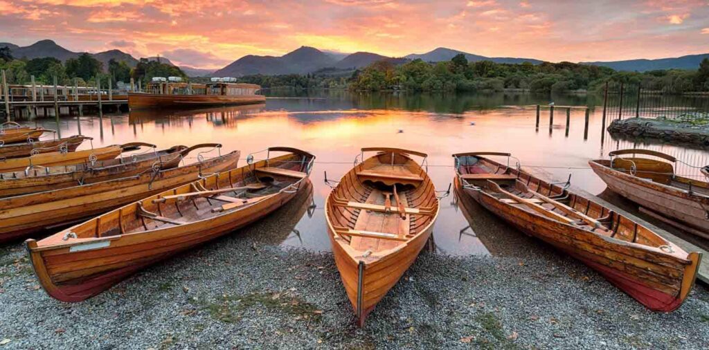 wooden rowboats parked on the shore of Derwentwater at Keswick in the Lake District National Park.