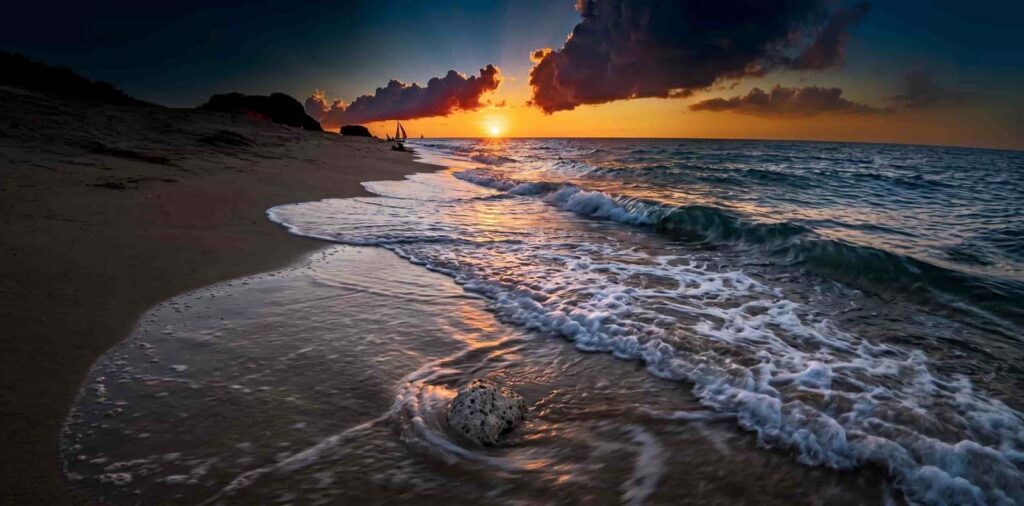 This image captures a vibrant sunset over the shore at Puka Beach in Boracay, Philippines